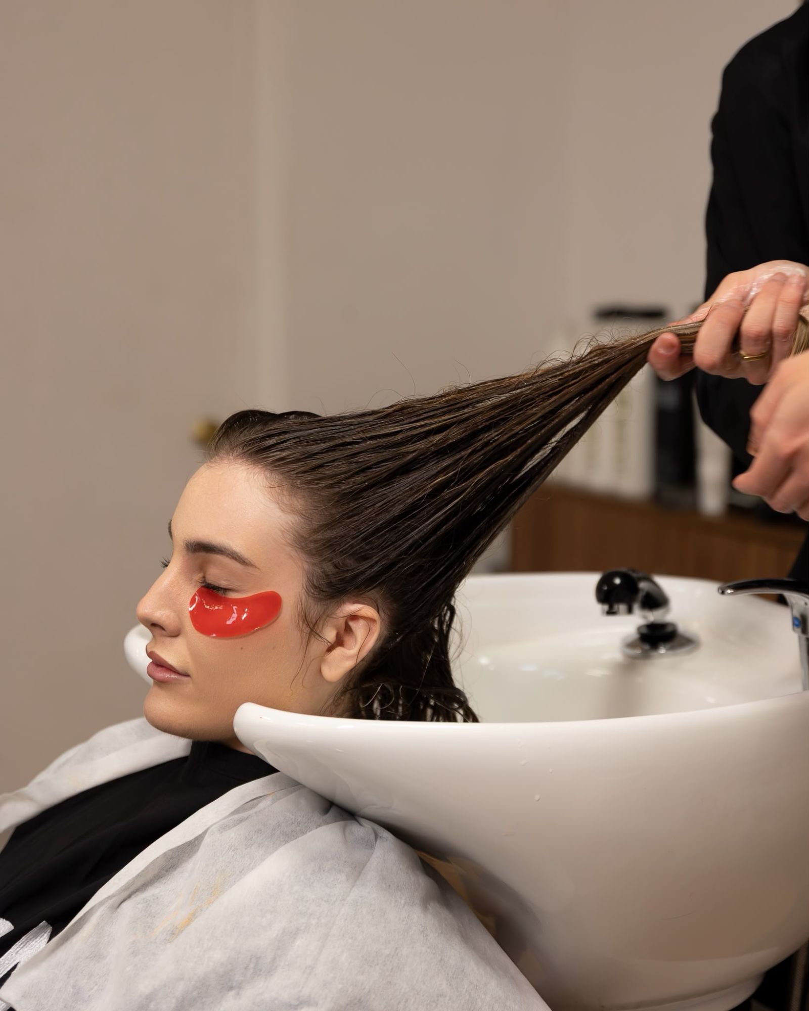 Clienta relajada en el lavacabezas de Sergio Torres Salon mientras le trabajan la melena, en El Ejido