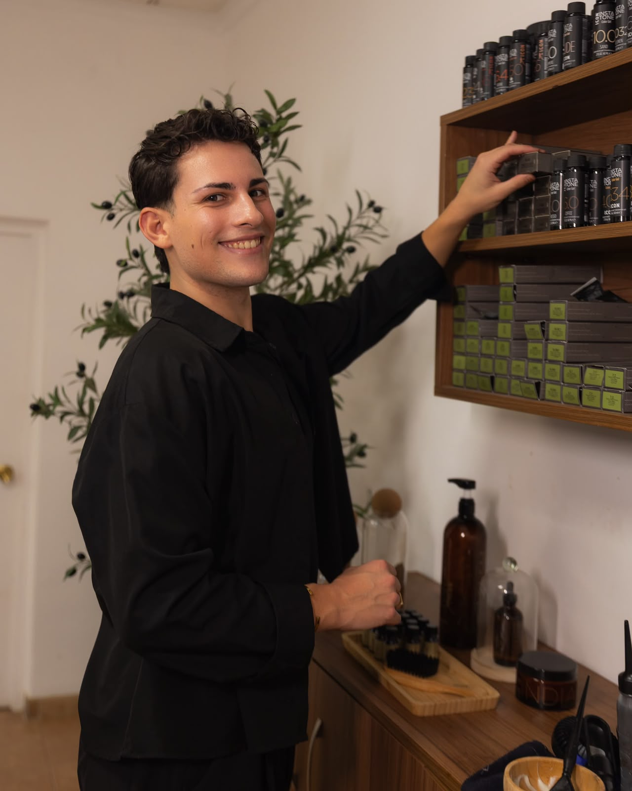 Sergio Torres sonriendo junto a la estantería de color del salón